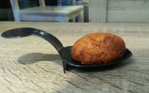 Croqueta de morcilla y almendras con violetas