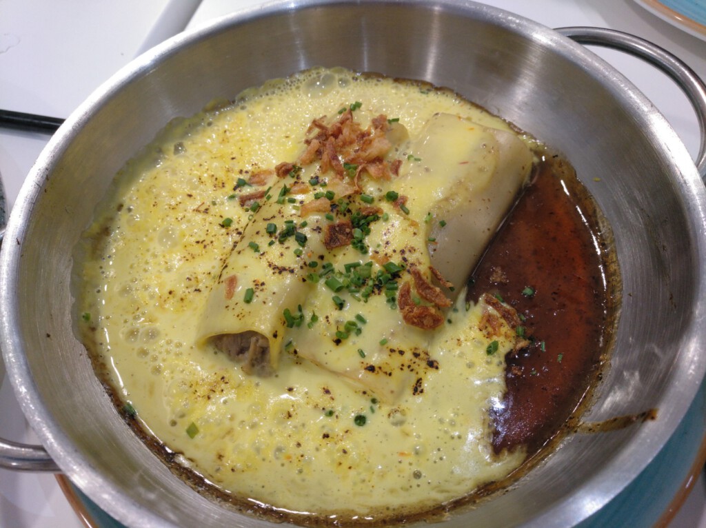 Canelón de pollo con bechamel de azafrán y salsa de tamarindo